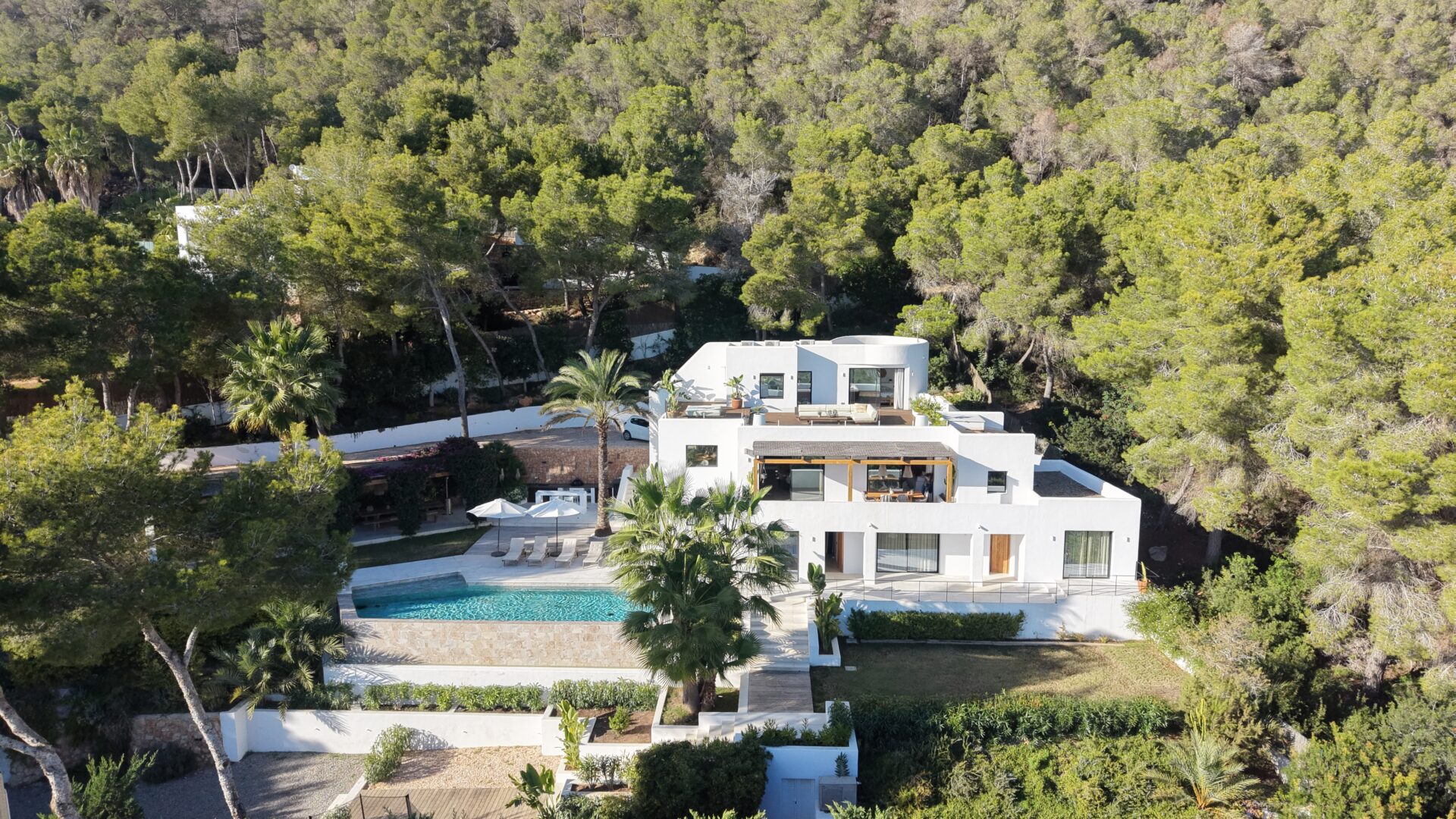 Aerial view of a white villa with pool among pines in Es Cubells, Ibiza