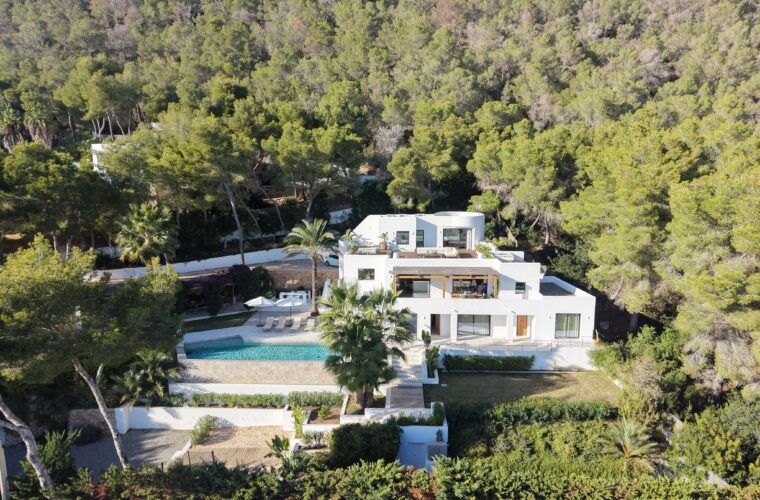 Aerial view of a white villa with pool among pines in Es Cubells, Ibiza